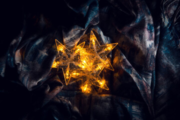 Three shining five-pointed stars, on an unusual background. Beautiful stars shining with golden color create a festive mood on the eve of Christmas and New year.