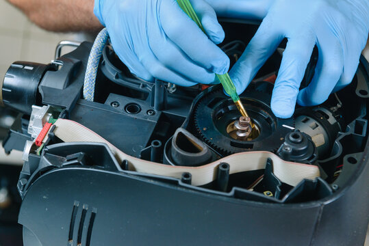 A repairman repairs a broken coffee maker