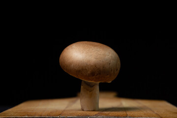 Brown champignons on a black background. Champignon variety. Healthy vegetarian food.