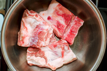 Pork ribs in a saucepan, close-up. Cooking at home.