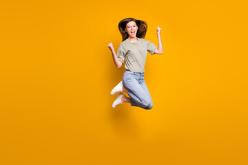 Fototapeta na wymiar Full length photo of crazy happy woman jump air up raise fists celebrate win isolated on yellow color background