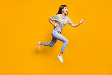 Fototapeta na wymiar Full length body size view of lovely motivated cheerful girl jumping running isolated over bright yellow color background