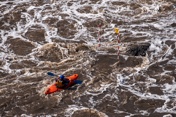 top view of a man sitting in a kayak and rowing desperately. among the stormy river. dangerous sport