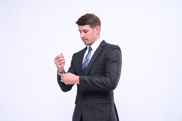 Portrait of elegant young caucasian handsome businessman in formal suit standing Isolated on white background in studio. Straightening cufflinks