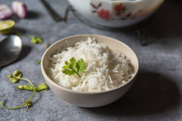Coriander leaf on cooked basmati rice served in a bowl with use of selective focus