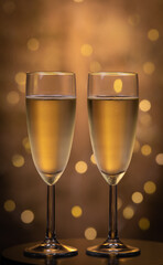 Champagne glasses over holiday bokeh blinking background, glasses with sparkling wine, celebration, party