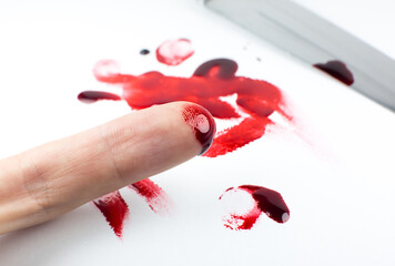 Man cut her finger with a knife. Finger with blood. Red Bloody fingerprints on the white...