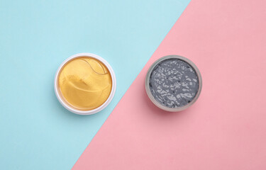 Black clay and golden patches on pink blue background. Beauty products, cosmetics. Top view