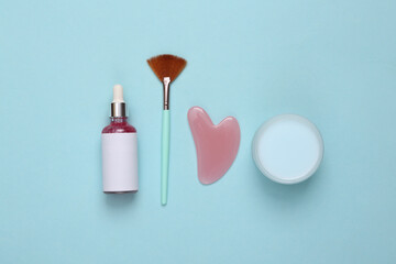Set for facial care on blue background. Flat lay beauty composition. Skin care, lifting face concept
