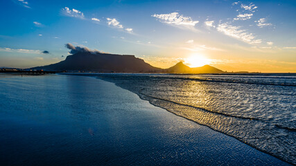 Obraz premium A beautiful sunset over the Table mountain in South Africa from the Lagoon beach. 
