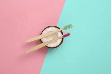 Eco toothbrushes with coconut on blue pink pastel background