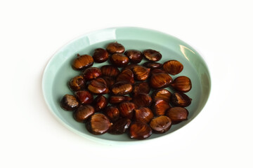 Ripe chestnuts on a plate, sharpened in water. Healthy food. Isolate. Photo