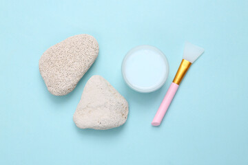 Jar of face cream with natural stones on turquoise background