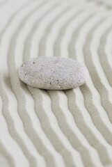 Fototapeta na wymiar Beige stone on sand with pattern lines, zen garden, meditation, harmony. Neutral colors.Poster