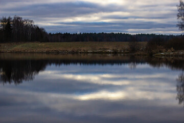 Forest reflection in water surface. Colors frame: yellow, blue, green. 