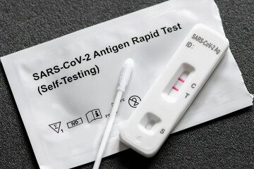 Positive Covid-19 antigen test kit for self testing, one step coronavirus antigen rapid test, saliva swab, 1 test box, close up - obrazy, fototapety, plakaty