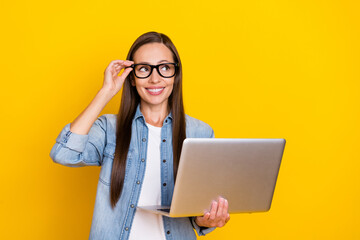 Photo of young lady wondered look empty space minded representative laptop isolated over yellow color background.