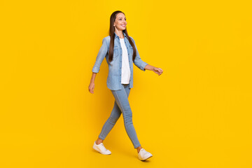 Fototapeta na wymiar Full body profile side photo of young adorable lady go wear casual outfit look empty space isolated over yellow color background