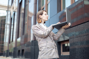 Young woman catches wifi with laptop in the city