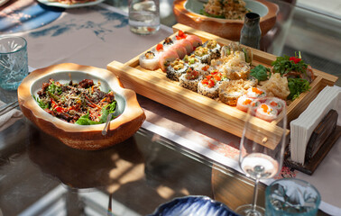 Sushi set on a wooden serving and salad close-up on the table. Japanese food