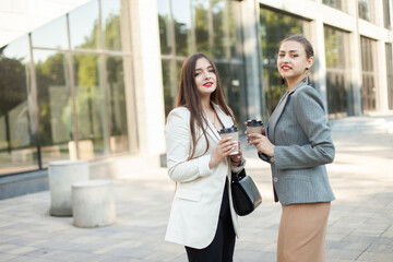 Two business women drinking coffee outdoors