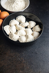 Fototapeta na wymiar vareniki raw dough stuffed dumplings ready to eat meal snack on the table copy space food background