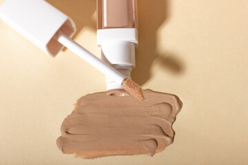 Concealer cream on a background with shadows. Face corrector on beige background with copy space....