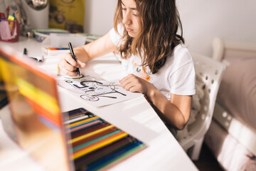 Teenage girl colouring on a poster board the figure of not exceeding the increase of the earth's temperature by more than 1.5 degrees Celsius in the next decade. Social demand for future generations