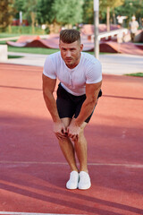 man in white t-shirt on the sports ground workout motivation