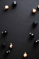 Christmas poster with bronze and black baubles on dark background. Vertical Xmas banner design....