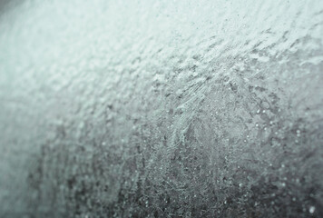Frozen car window, frozen glass texture. A car window covered with ice in winter.