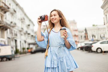 Young cute woman tourist with camera in the city