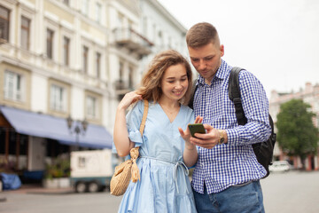 Young couple in love looking at the screen of smartphone