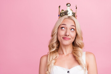 Photo of young girl happy positive smile wear crown queen dream think look empty space isolated over pink color background