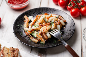 Baked potatoes on a white wooden background. With mayonnaise, ketchup, tomatoes.