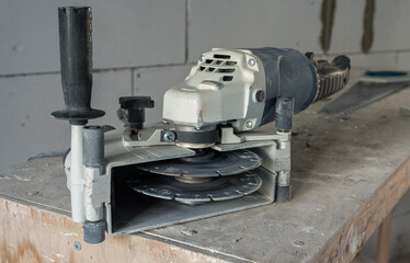 A hand-held power tool with two diamond discs for cutting grooves in the wall for laying electrics. Professional stroborez tool. Close-up. The concept of renovation of premises.
