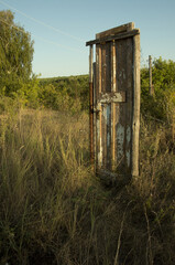 An old wooden door with white scuffed paint in the middle of the road on a summer day