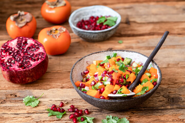 Persimmon Salsa. Healthy vegetarian bowl salad with Persimmon, pomegranate, cucumber, onion and cilantro.
