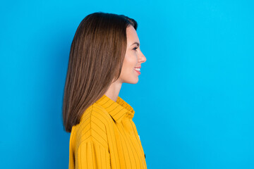 Profile side photo of cheerful young lady good mood look empty space isolated over blue color...