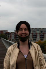 Fototapeta premium Pedestrian with Mask on Chin _ Pedestrian Bridge City Scape Views in Autumn Chattanooga Tennessee