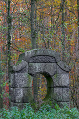 old stone pillars in the forest overgrown with plants