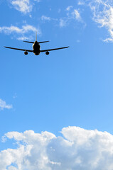flight of the airplane (jet) over beautiful blue sky with white clouds