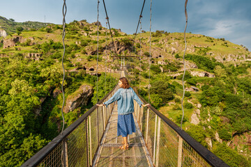 Woman traveler at the famous suspension bridge in Khndzoresk, Armenia, leading tourists to the...