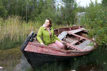 Woman sitting in old wooden boat