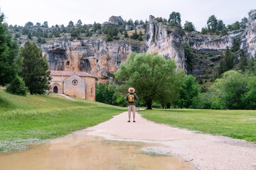 Fototapeta premium Panoramic view of unrecognizable man walking isolated in nature with backpack. Horizontal view of man traveling alone in the Lobos river canyon in Soria. People and travel destinations in Spain.