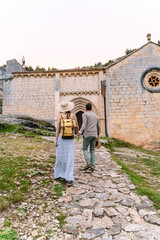 Fototapeta na wymiar Panoramic view of unrecognizable couple sightseeing a chapel in nature. Vertical view of couple traveling in the Lobos river canyon in Soria. People and travel destinations in Spain.