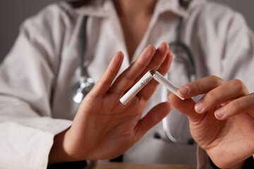 hands doctor break a cigarette close-up. smoking harm concept.