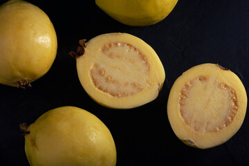 Yellow guava on black background, still life style. Healthy diet