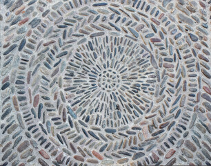 Multicolored pebble paved road, round geometric pattern underfoot in the city
