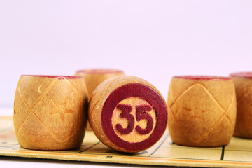 Family board game Lotto. Wooden barrels loto numbered 35 on a white background